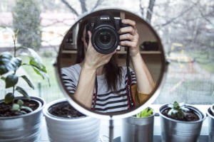 Woman aiming camera at a mirror